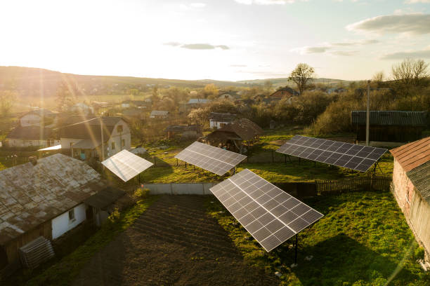Aerial top down view of solar panels in green rural village yard.